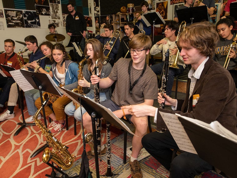 A group of high school and Oberlin students take a music class.