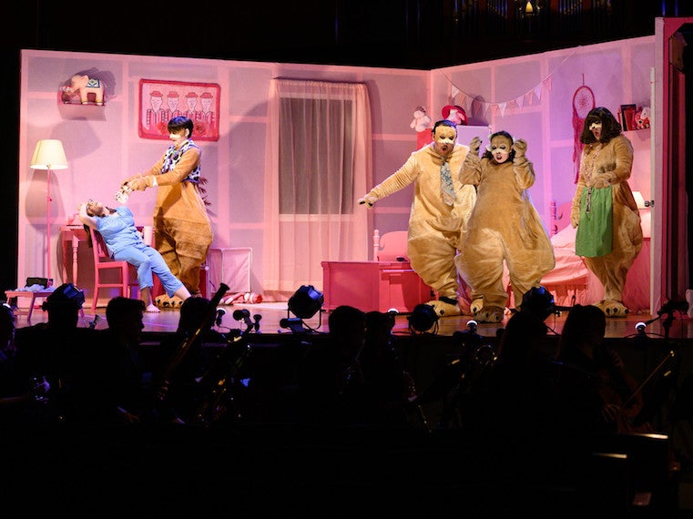 Actors in prairie dog costumes surround a female actor during an opera performance.
