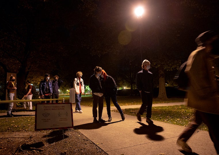 People walking down a pathway at night.