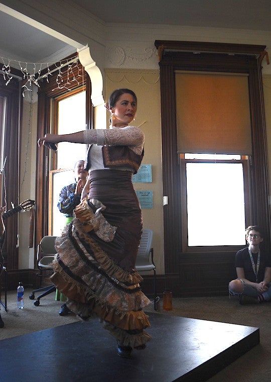 A woman twirls on a platform.