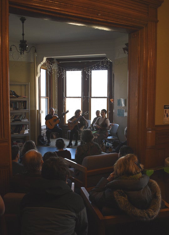 A room cull of people look at performers in the front of a room.