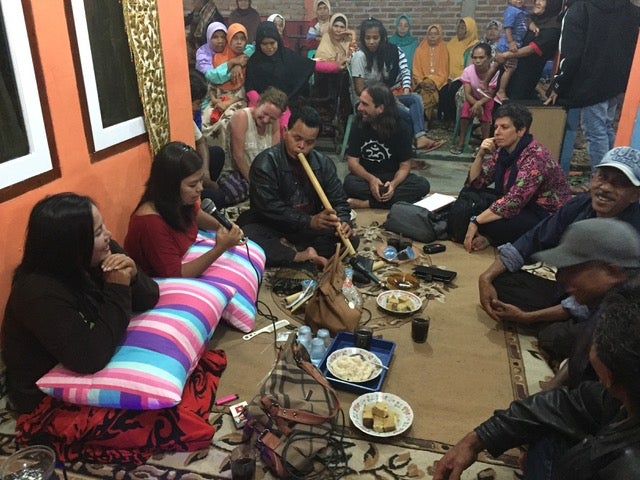 People sitting on the ground playing music.