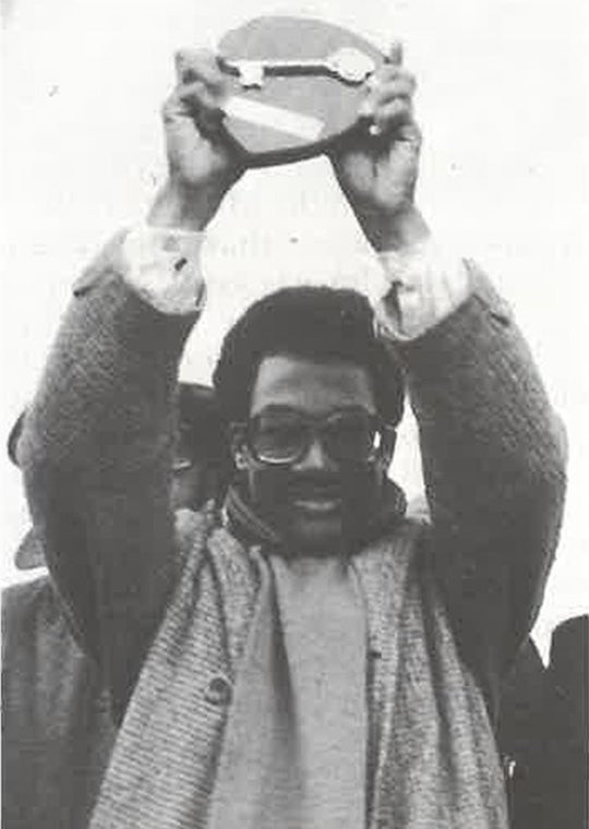 A students holds up a plaque with a key on it,