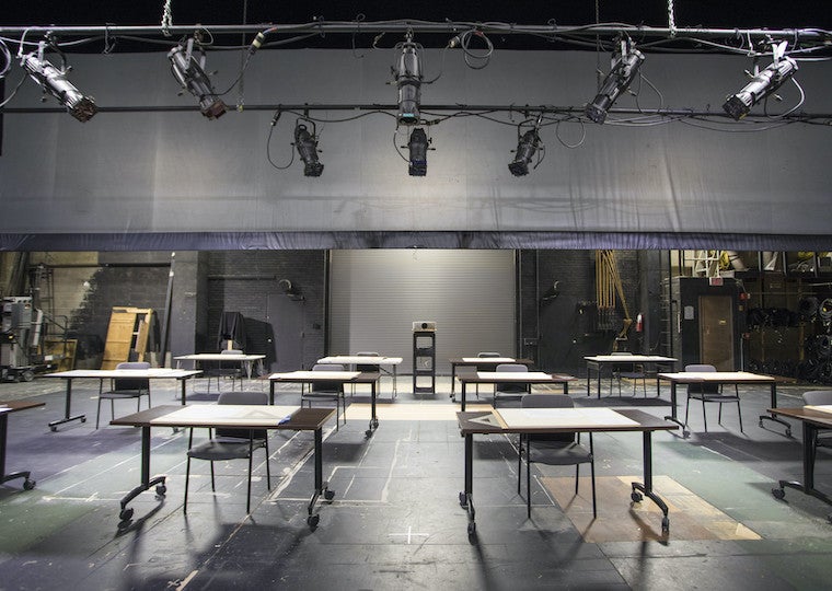 Desks and chairs on a large stage.