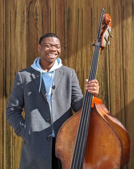 A male student holding a cello