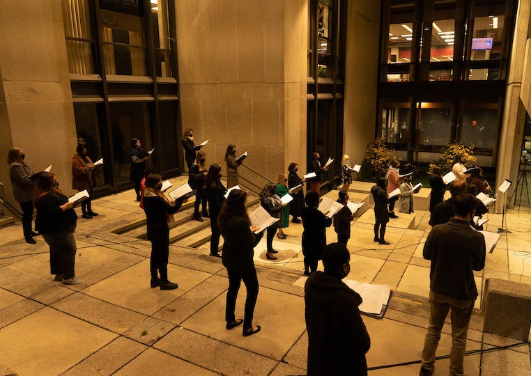 A choir gives an outdoor night performance.