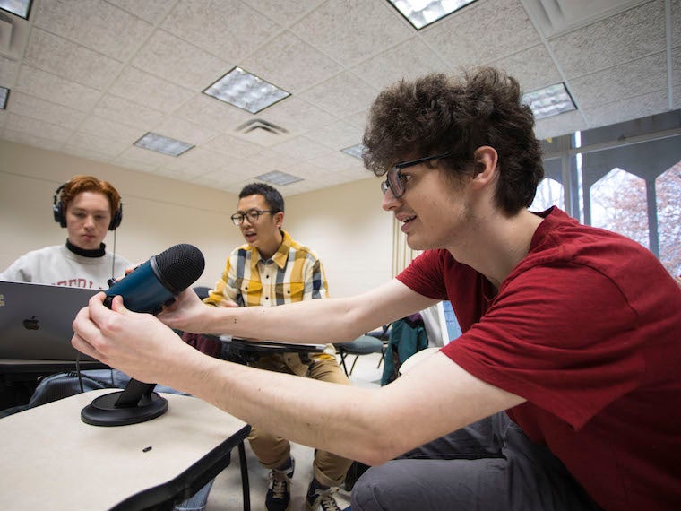 A student holds a large microphone.