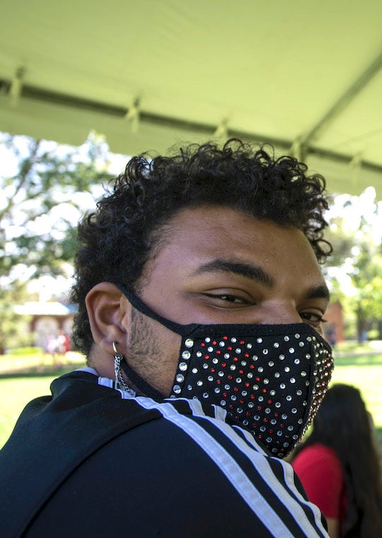 A student wears a studded mask
