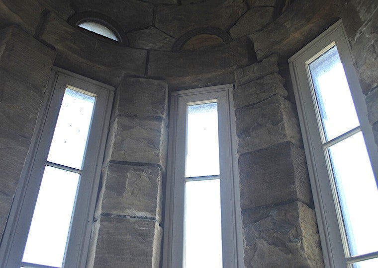 Three long windows on a stone wall.