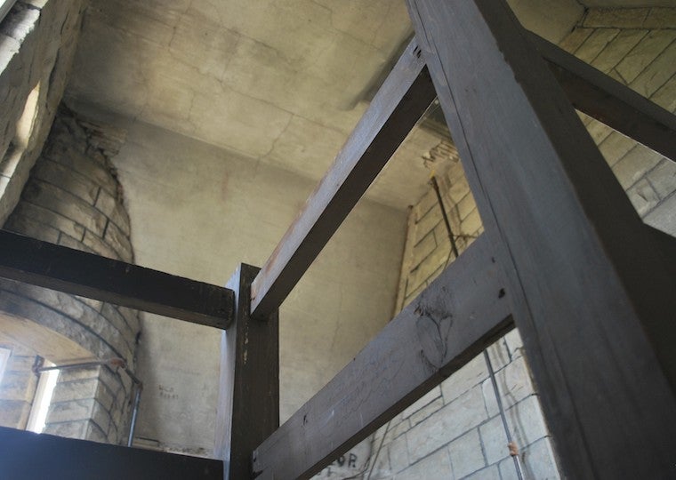 A wooden handrail and stone ceiling.