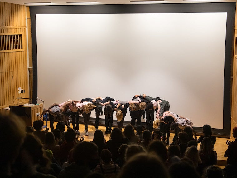 A group of people take a bow on stage.