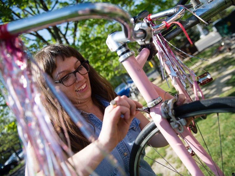 A girl wrenches on a bike.