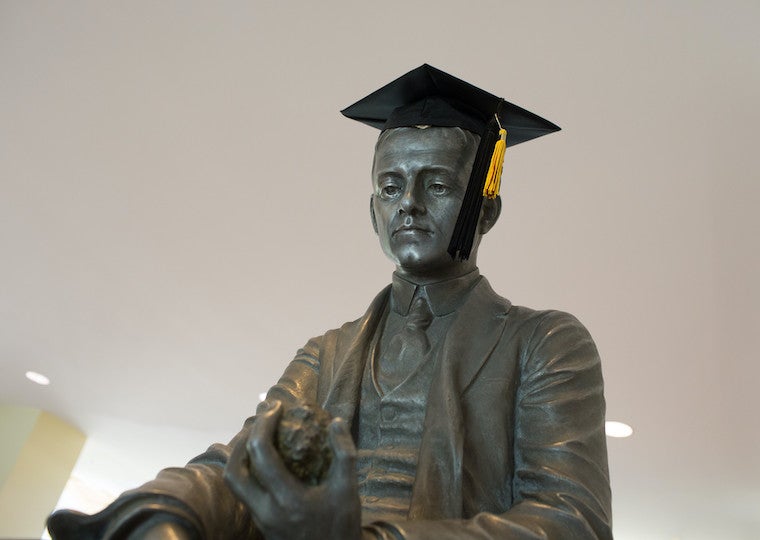 A statue of a man wearing a graduation cap.
