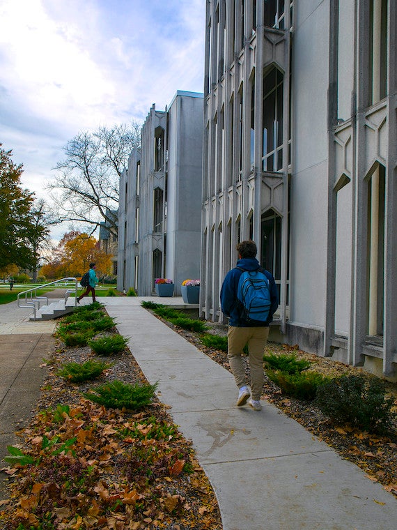 Two students walk to a building.