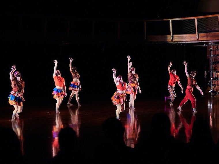 A group of students dance on a large stage.