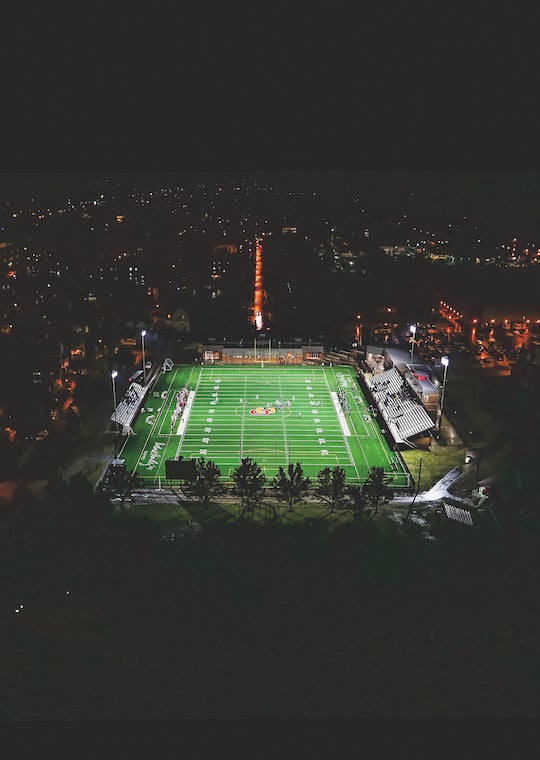 A drone picture of a football field taken at night.