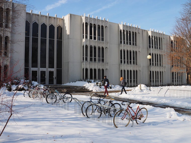 Bikes parked in front of a building in the snow,