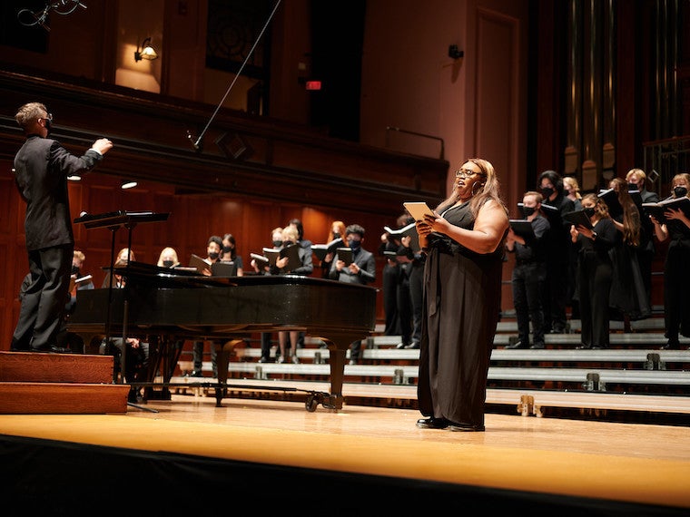 A singer stands in front of a choir.