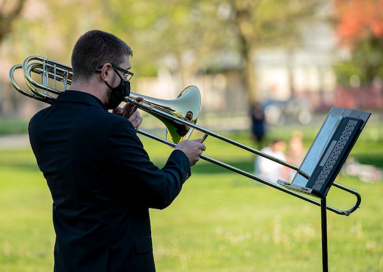 A man playing a trombone outside.