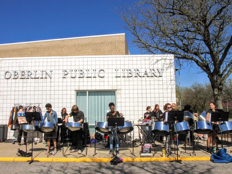 An steel band plays in front of a library.