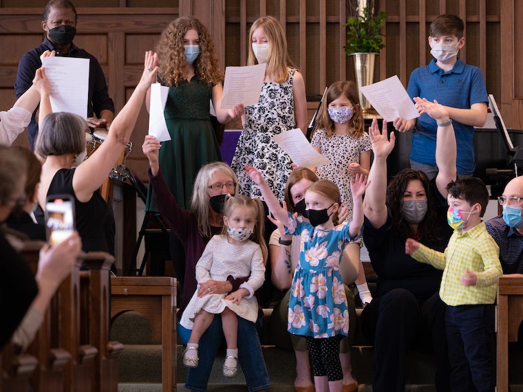 Children sing in front of a church.