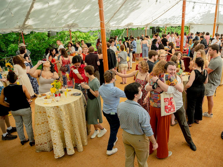 People attend a party under a large tent.