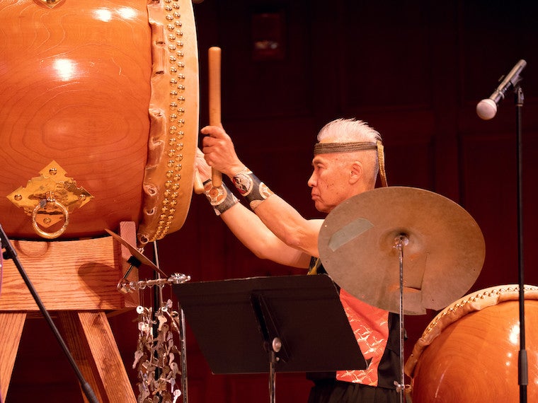 A man hits a large drum.