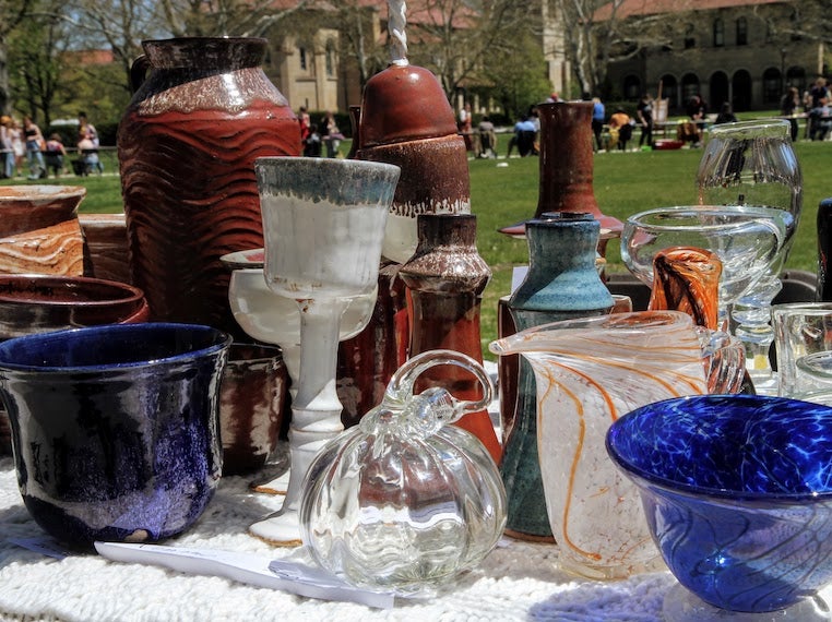 Pottery and blown glass sit on a table.