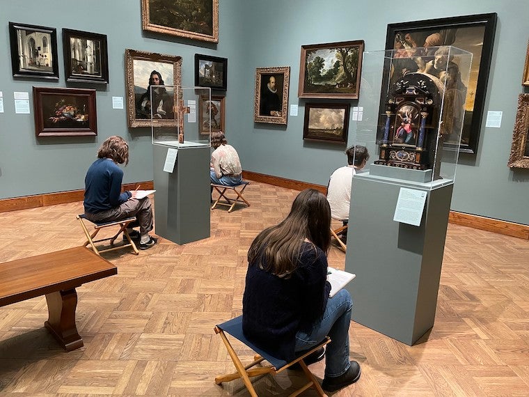 Students look at art in a museum.