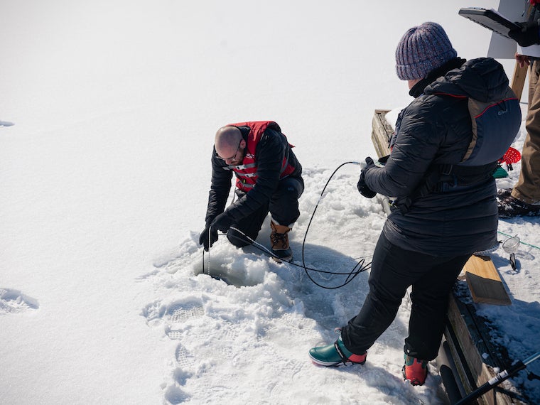 Student researcher collects Lake Erie water samples hole in the ice