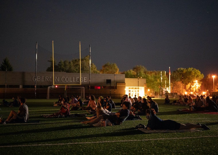 People watching a movie in a football field