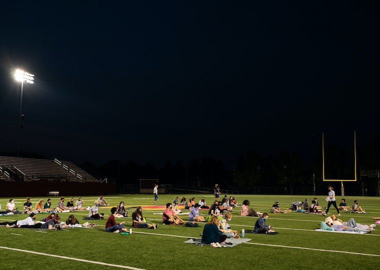 People watching a movie in a football field