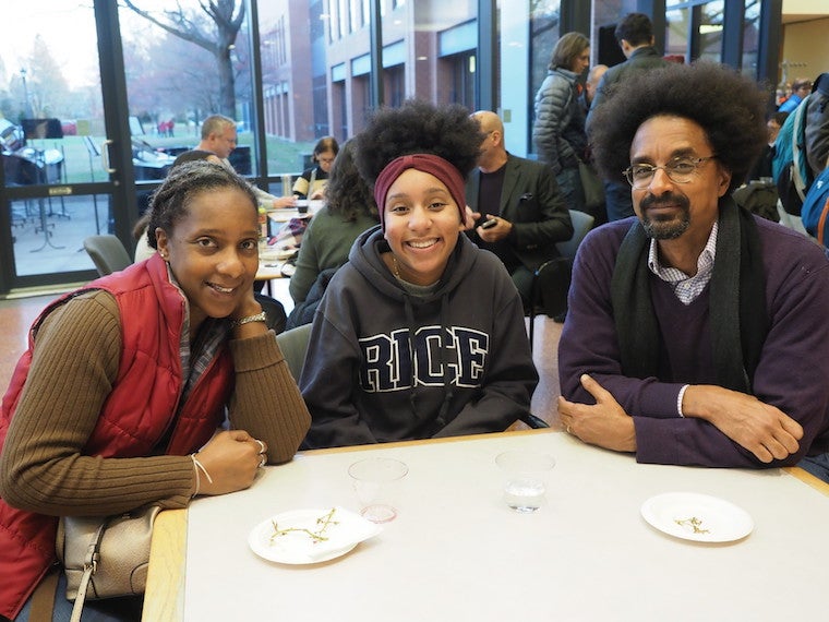 Three people sit at a table during a reception.