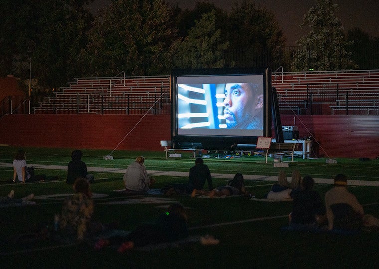 People watching a movie in a football field