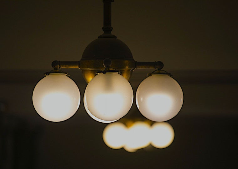 Round bulbs hang in a brass chandelier