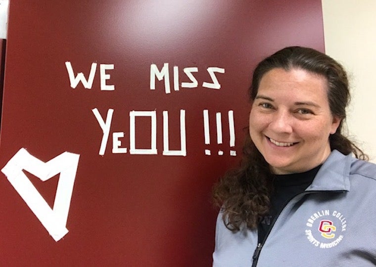 A girl next to a we miss yeo sign.