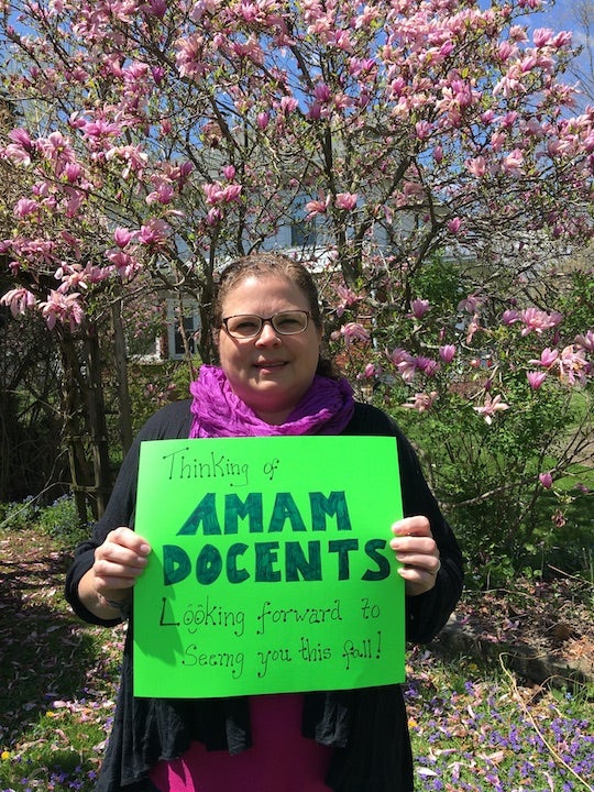 A woman holds a sign.