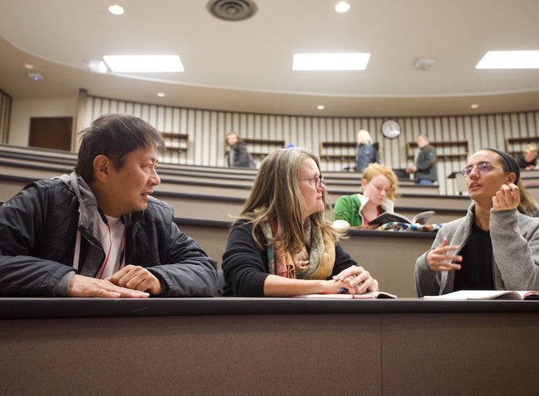 Parents and their student sit in a seminar room just before class starts.