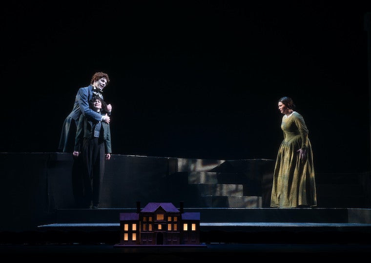 A man holds a another man while a woman looks on.