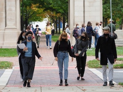 Professor and students cross the street near Memorial Arch.