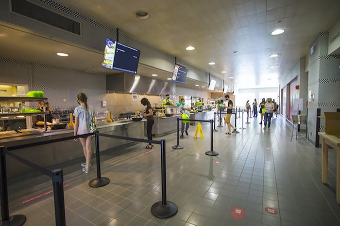 Students get their meals in a cafeteria.