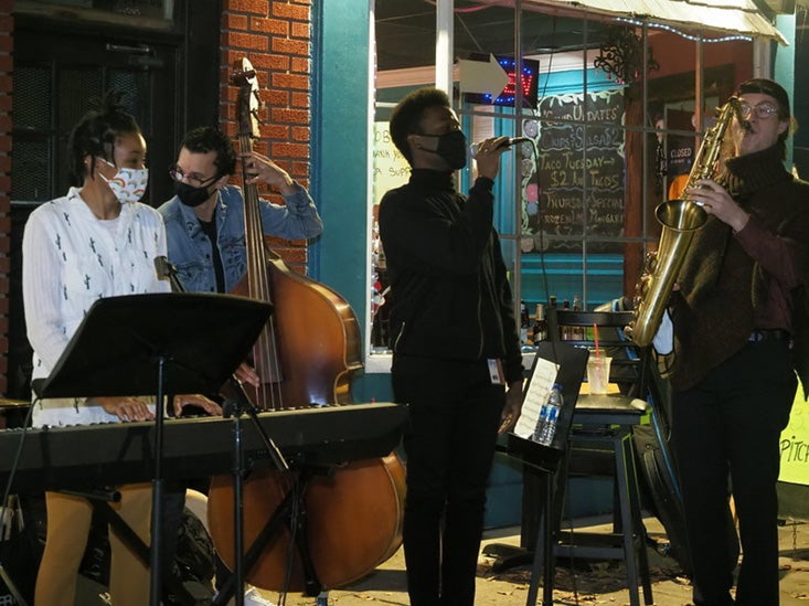 A jazz quartet performs on the sidewalk.