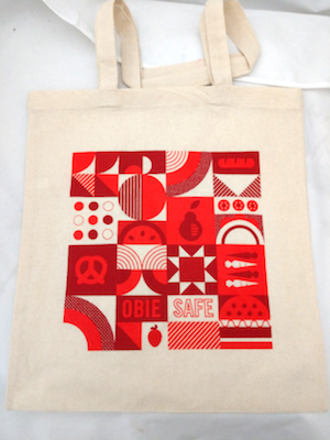 ObieSafe canvas tote bags featuring geometric designs in red hues. The text reads ObieSafe.