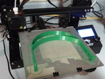 A 3-D printer produces a face shield.