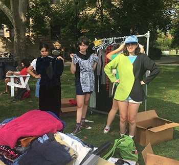 Students holding up donated clothing items