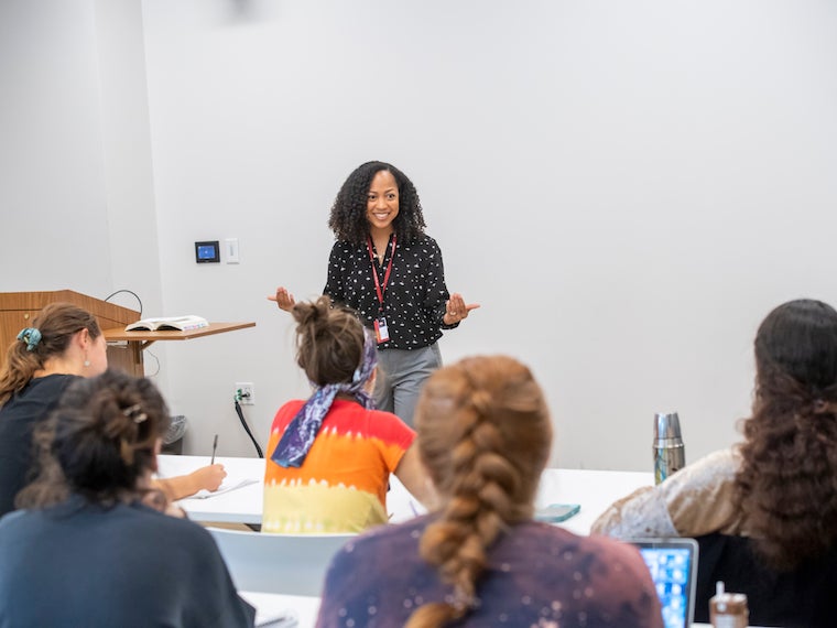 female professor talking in front of classroom of students.