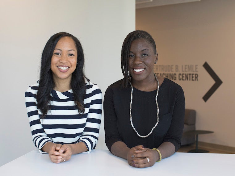 two women sitting side by side at a table