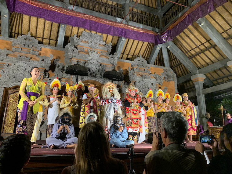 about twenty people in intricate costumes stand onstage