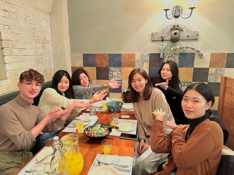 Me and five other students along with my flute professor sitting together at a dinner table.