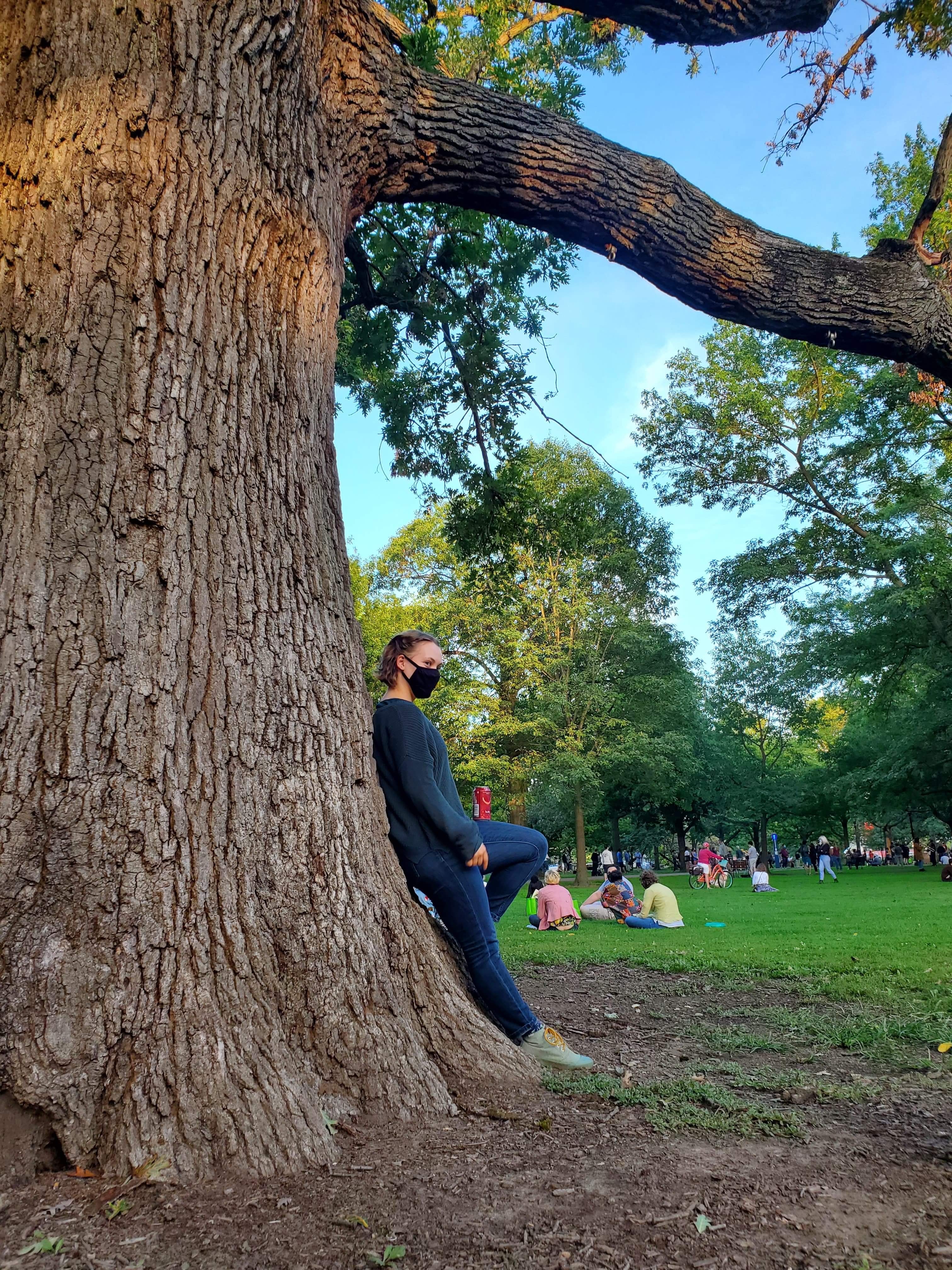 Ruth leaning against a green tree in Tappan Square